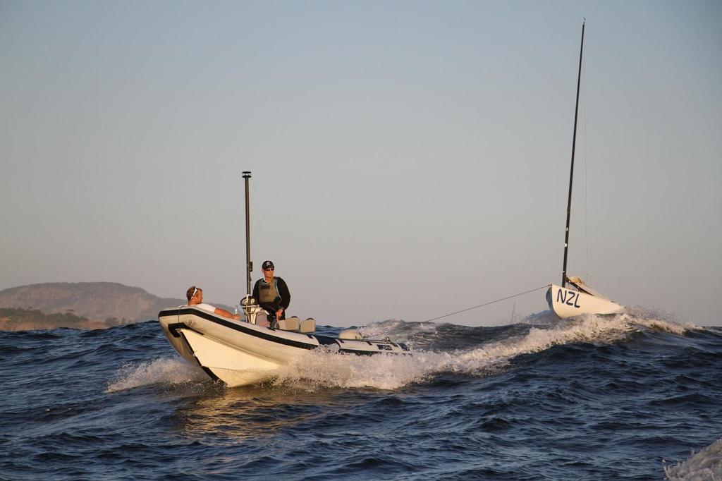 Day 7 - Finn August 14, 2016. Josh Junior (NZ) being towed home after race 10 in the Finn class © Richard Gladwell www.photosport.co.nz